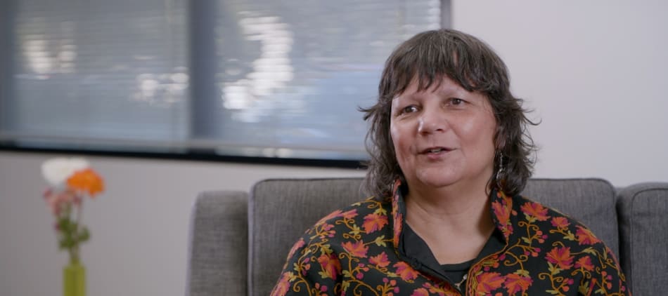 Photo of a woman sitting on a couch talking